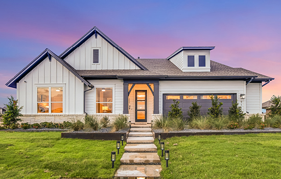 A one-story model home is built on a non-Premium Homesite. Landscaping is placed in front of the garage, which will be replaced with a driveway when the model home is sold.