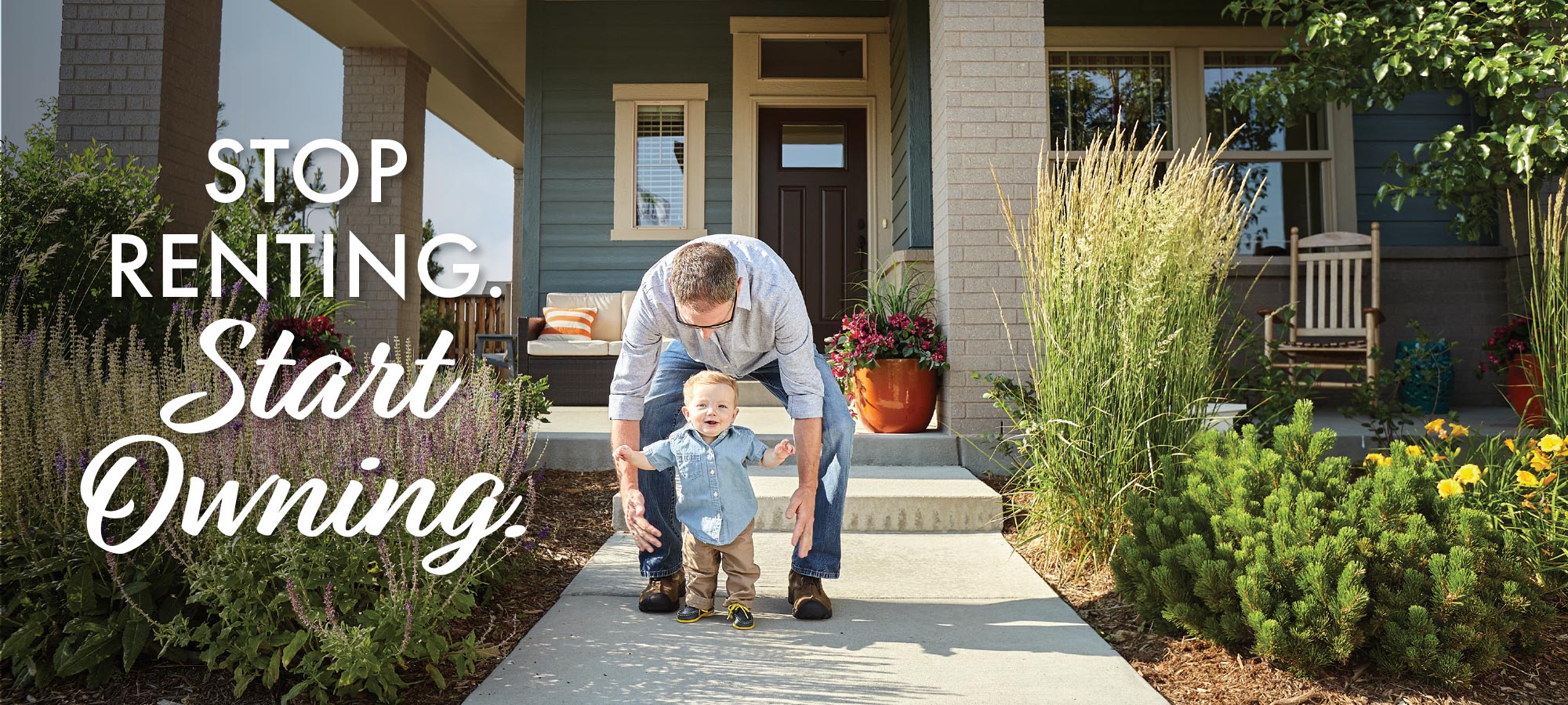 father walking with baby in front of a David Weekley home