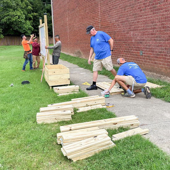 David Weekley Homes Team Members working on constructing items for school classrooms