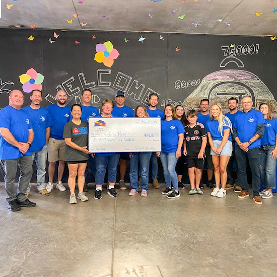 David Weekley Homes Team Members posing with a large donation check