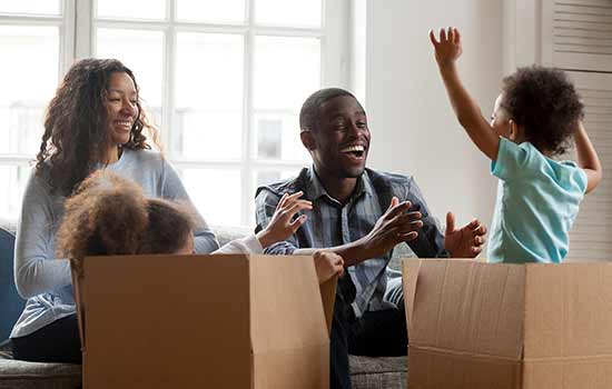 family with smal children playing in moving boxes